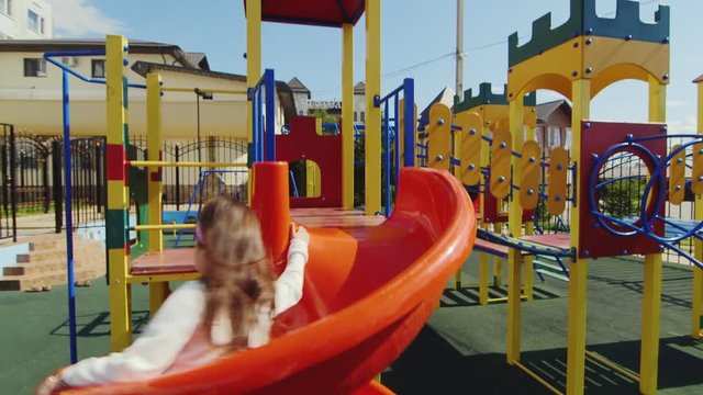 Girl 6 years coming down with a children's slides on the playground