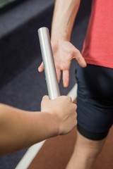 Athlete passing a baton to the partner