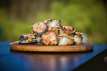 cooking rolls of mackerel on the grill, eating
