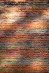 close up view of lights and shadows pattern on red brick wall