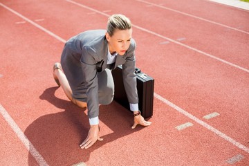 Businesswoman with briefcase in ready to run position