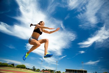 Fototapeta na wymiar Female athlete performing a long jump