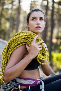 Portrait of woman sitting with climbing equipment 