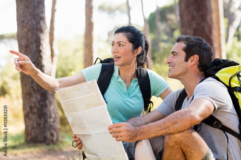Poster Couple pointing and holding a map 