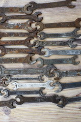 Set of old spanners. Rough spanners on wooden background. Frame of metallic tools 