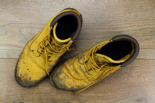 Muddy work boots on a wooden floor