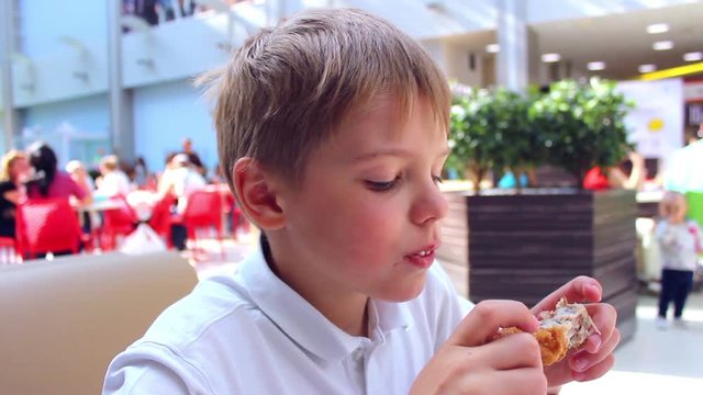 the child eats a chicken in a fast food