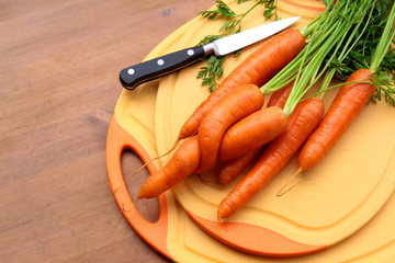 Frische verleibte Bio Karotten auf Schneidbrett mit Messer