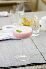 Pink cocktail in glass with high leg