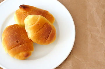 tre cornetti in un piattino bianco, dall'alto, sfondo naturale