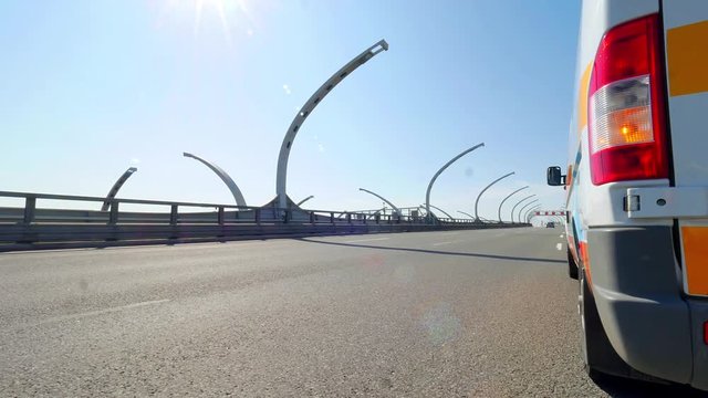 car rides on a modern empty highway on background of a van with emergency stop sign