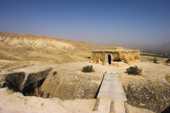 Wooden bridge across chasm leading to Buddhist stupa carved out of rock, Top-I-Rustam (Rustam's throne), an early burial mound that contained Buddha relics dating from the 4th and 5th centuries AD, near Haibak, Samangan Province, Afghanistan