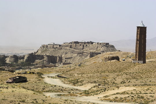 Military graveyard and one of two 12th century minarets that served as models for the Minaret of Jam, with ancient city walls and Citadel in the background, Ghazni, Afghanistan