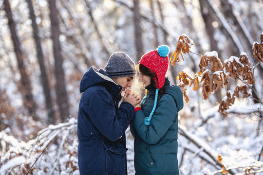 Side view of romantic young couple holding hands during winter