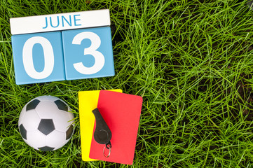 June 3rd. Image of june 3 wooden color calendar on green grass background with football outfit....