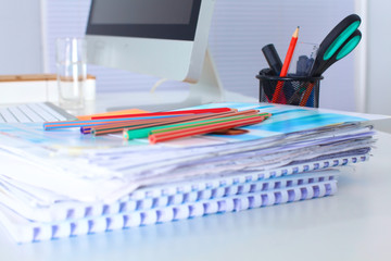 Designer working desk with a computer and paperwork