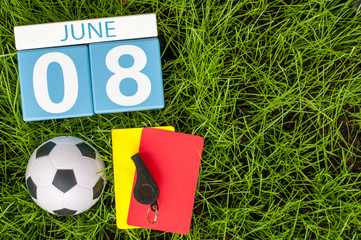 June 8th. Image of june 8 wooden color calendar on green grass background with football outfit....