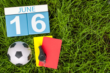 June 16th. Image of june 16 wooden color calendar on green grass background with football outfit....