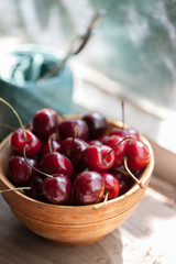 Cherries in a wooden bowl on a wooden table 