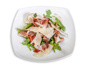 Salad: Arugula, Parmesan cheese and Parma ham. On a white plate isolated on white background