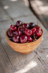 Cherries in a wooden bowl on a wooden table 
