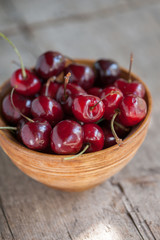 Cherries in a wooden bowl on a wooden table 