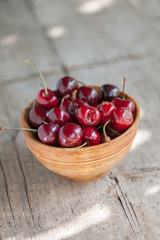Cherries in a wooden bowl on a wooden table 