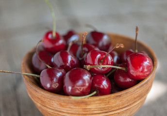 Cherries in a wooden bowl on a wooden table 