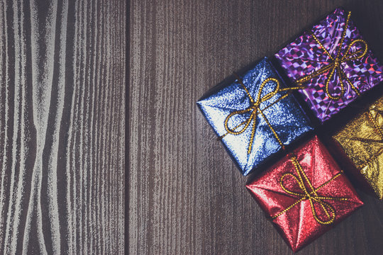 colorful present boxes over brown wooden background