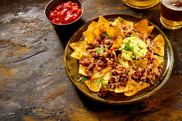 Chips with cheese, meat, guacamole and salsa