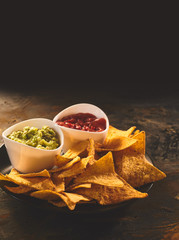 Plate of tortilla chips, guacamole and salsa dip
