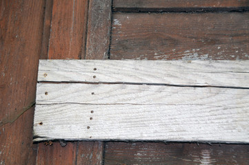 Nailed wooden board on an abandoned weathered wooden cabin