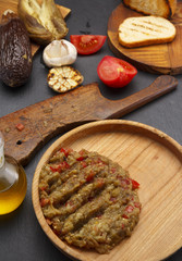 Egplant caviar ( salad ) on a wooden rustic plate over dark table