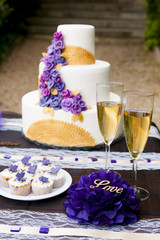Wedding table arrangement with wedding cake, mini muffins, champagne glasses and other decorations