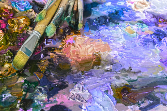 artist's palette with oil paints and brushes used for painting a