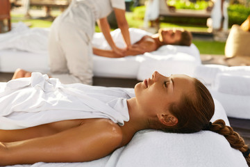 Spa Couple Massage. Beautiful Happy Smiling Woman And Healthy Man Enjoying Relaxing Body Massage Treatment Outdoors At Beauty Salon. People At Romantic Day Spa Resort. Health Care And Relax Concept