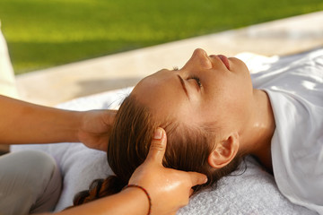 Spa Massage. Masseur Hand Massaging Girl's Head With Aromatherapy Oil. Closeup Of Beautiful Healthy Happy Woman Relaxing In Day Spa Salon Outdoors. Relax Beauty Body Care Treatment Concept