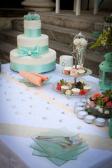 Wedding table arrangement with wedding cake, mini muffins, champagne glasses and other decorations