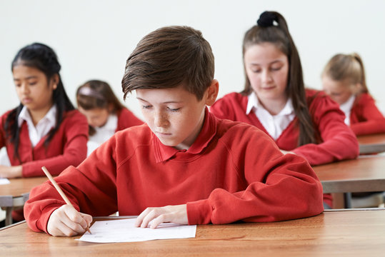 Male Pupil At Desk Taking School Exam