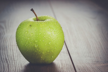 fresh green apple on the brown wooden table