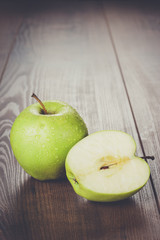 fresh green apples on the brown wooden table