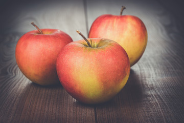 fresh red apples on the brown wooden table