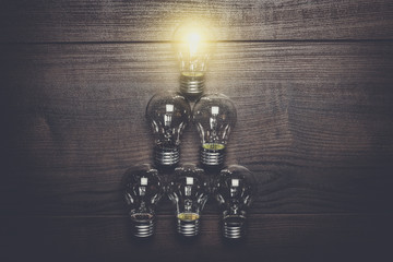glowing bulb leadership concept on brown wooden background