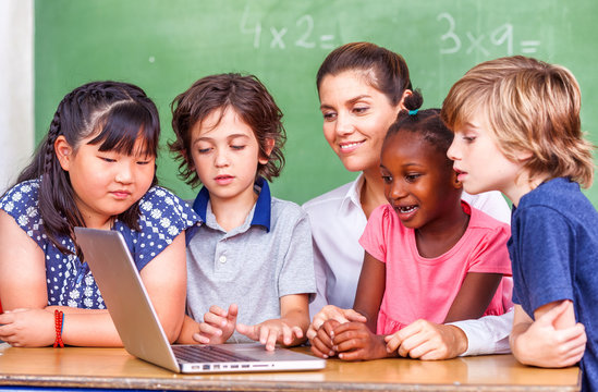 Beautiful teacher with mixed race classroom - Powered by Adobe