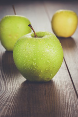 fresh green apples on the brown wooden table