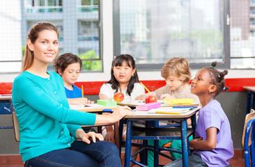 Fototapeta premium Beautiful teacher with mixed race classroom
