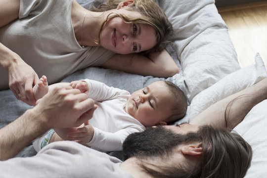 Happy family relaxing on bed