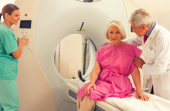 Old female patient undergoing mri in hospital assisted by doctor