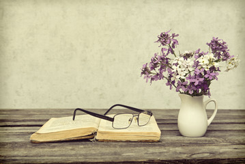 The old book with eyeglasses on a wooden table