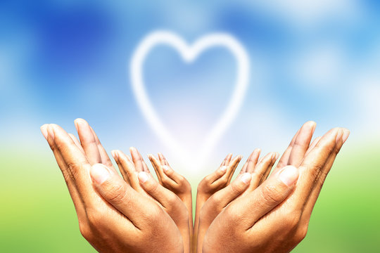 Human hands protecting heart.Blur natural background